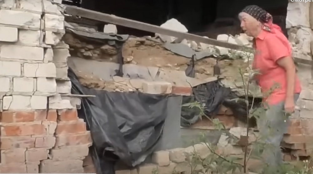 Клавдія біля розбитого російськими окупантами будинку